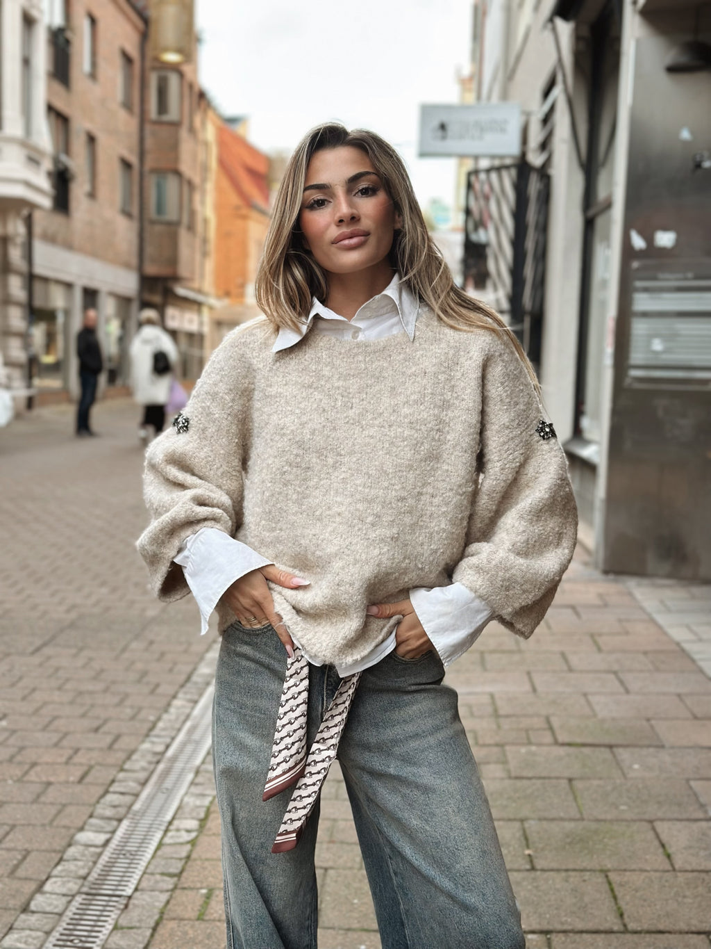 Stickad tröja med broschdetalj